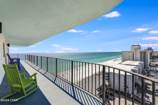 balcony with a water view and a view of the beach