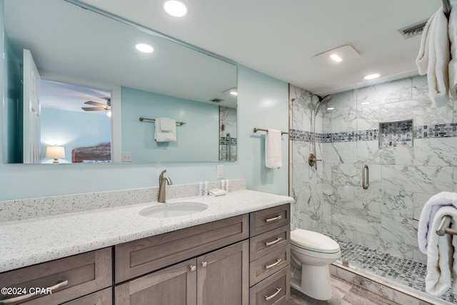 bathroom featuring ceiling fan, vanity, hardwood / wood-style flooring, an enclosed shower, and toilet