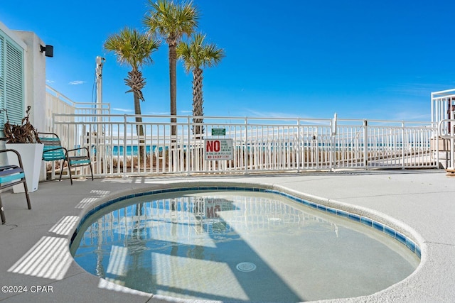 view of swimming pool with a water view and a patio area