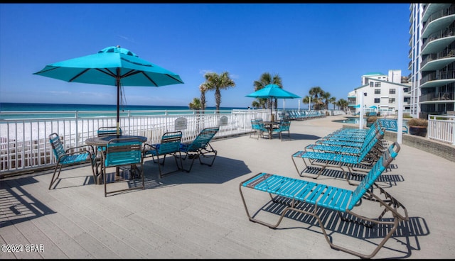 view of patio / terrace with a water view and a beach view