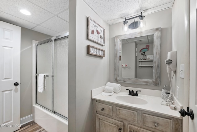 bathroom featuring enclosed tub / shower combo, a paneled ceiling, vanity, and hardwood / wood-style flooring