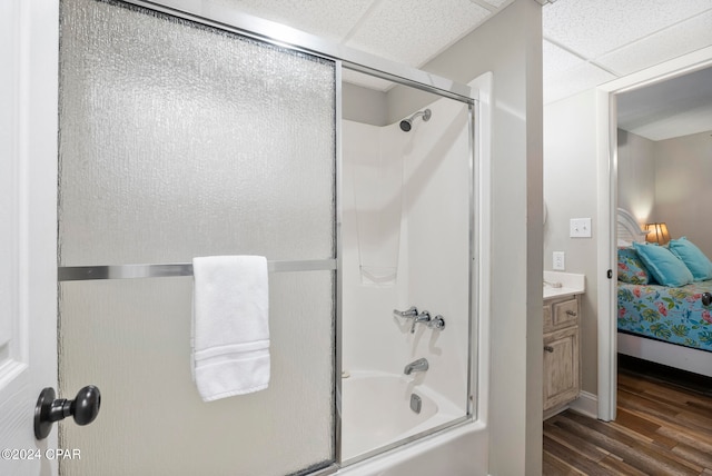 bathroom featuring enclosed tub / shower combo, vanity, a paneled ceiling, and wood-type flooring