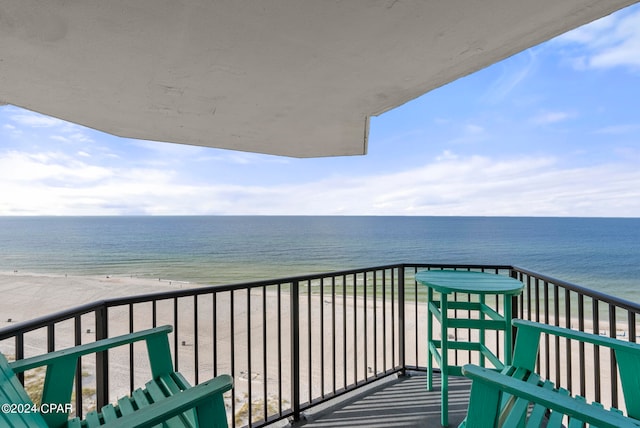 balcony featuring a water view and a beach view