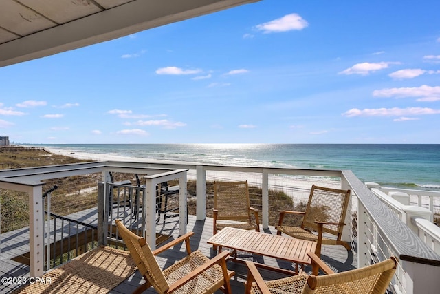 balcony with a water view and a view of the beach