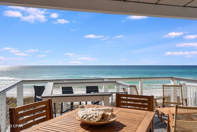 balcony featuring a water view and a beach view