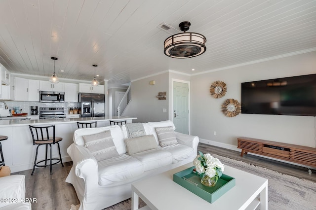 living room with light wood-type flooring, wooden ceiling, and crown molding