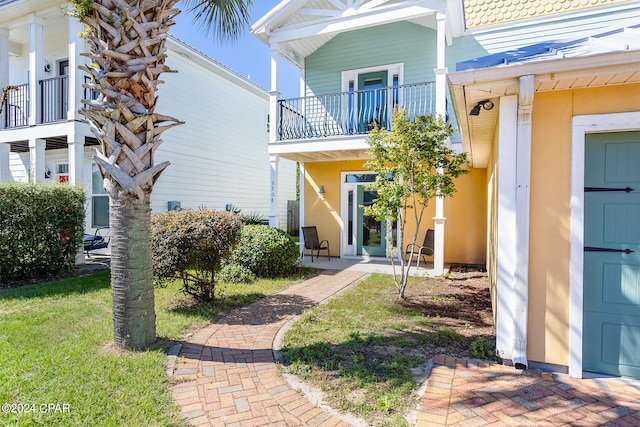 exterior space featuring a balcony and a lawn