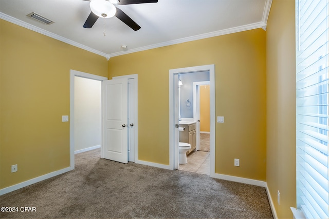 unfurnished bedroom featuring light carpet, crown molding, ensuite bathroom, and ceiling fan