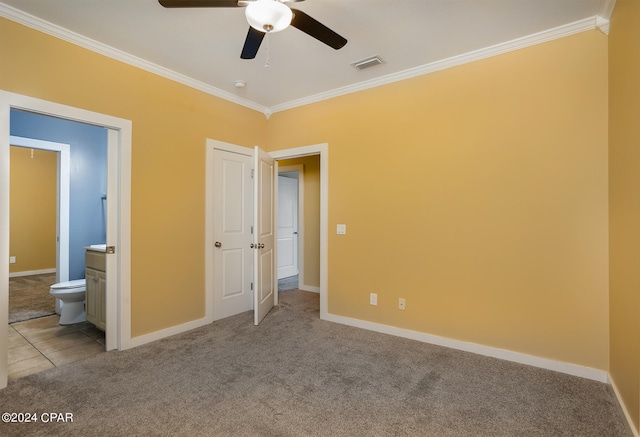 unfurnished bedroom with ceiling fan, crown molding, light colored carpet, and ensuite bath