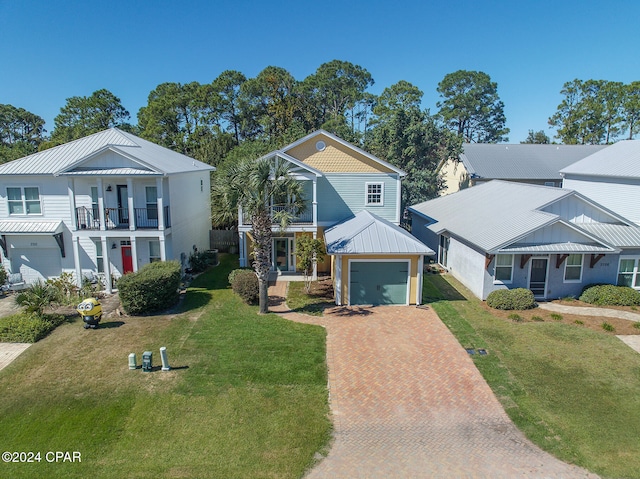 view of front of home with a garage, a front yard, and a balcony