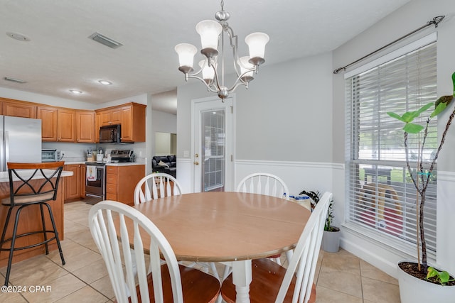 dining area featuring light tile patterned flooring and an inviting chandelier