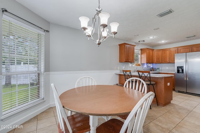 tiled dining space featuring an inviting chandelier