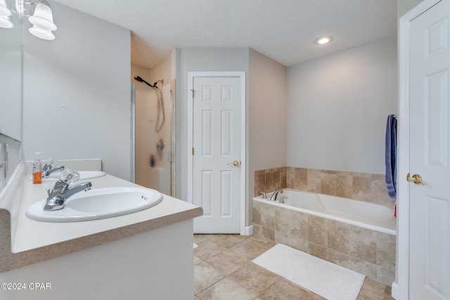 bathroom featuring a textured ceiling, tile patterned flooring, vanity, and separate shower and tub