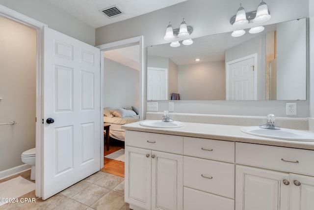 bathroom featuring vanity, a chandelier, toilet, and tile patterned floors