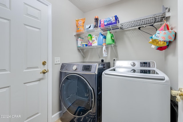 laundry area featuring a textured ceiling and washer and clothes dryer