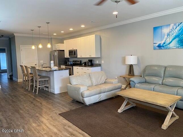 living room featuring ceiling fan, crown molding, and dark hardwood / wood-style flooring