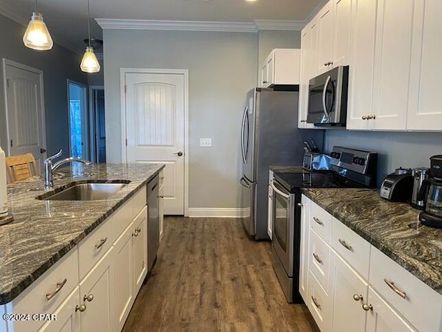 kitchen featuring dark wood-type flooring, sink, white cabinets, appliances with stainless steel finishes, and ornamental molding