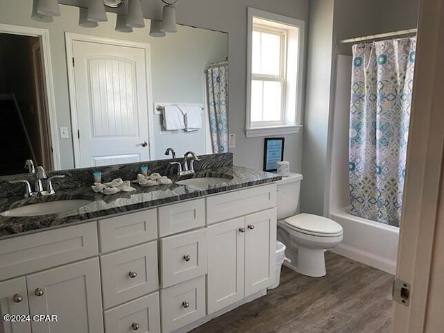 full bathroom with shower / tub combo, hardwood / wood-style floors, vanity, and toilet