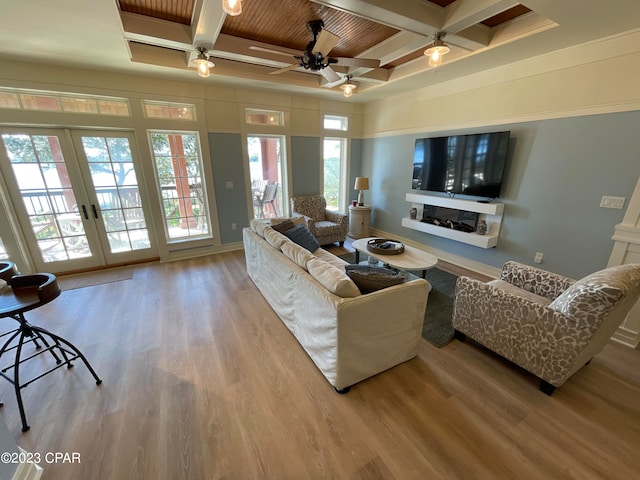 living room featuring beamed ceiling, coffered ceiling, light hardwood / wood-style flooring, ceiling fan, and french doors