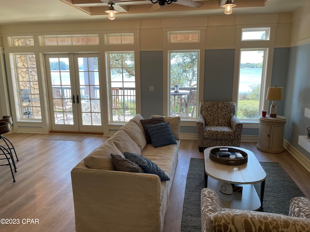 living room featuring a healthy amount of sunlight, ceiling fan, french doors, and hardwood / wood-style flooring