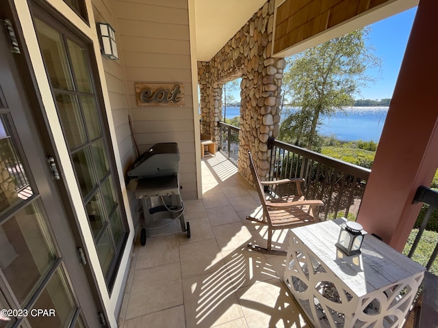 balcony with a water view and a grill