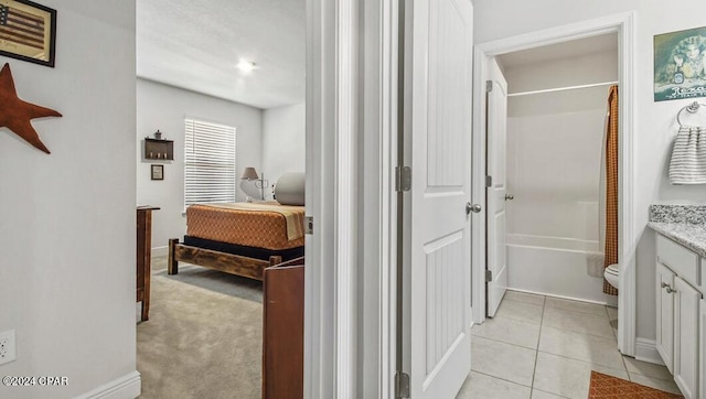 full bathroom featuring tile patterned flooring, vanity, toilet, and shower / bath combo with shower curtain