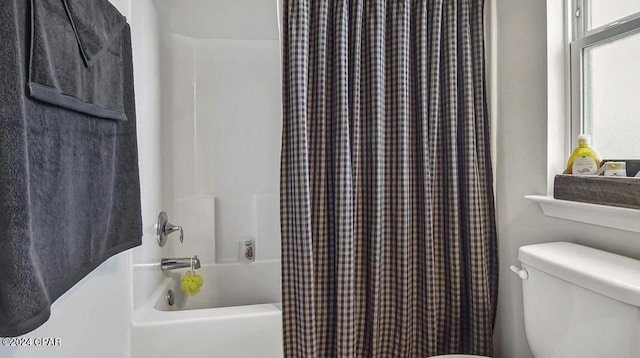 bathroom with shower / bath combination with curtain and toilet