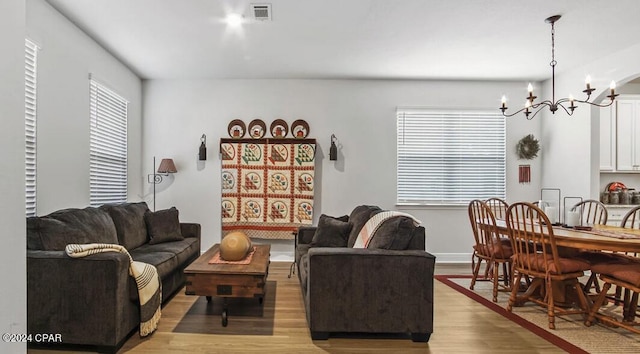 living room featuring light hardwood / wood-style flooring and a notable chandelier