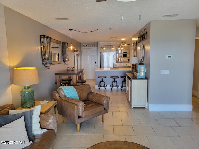 living room featuring a textured ceiling and light tile patterned flooring