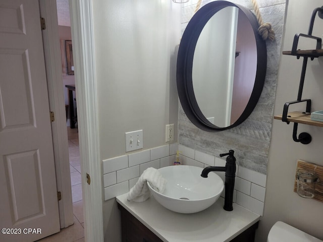 bathroom with tile patterned floors, vanity, toilet, and tile walls