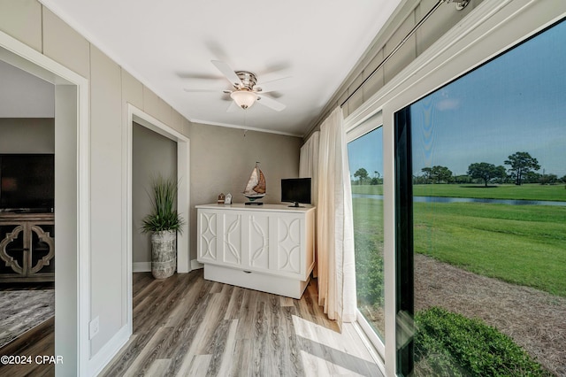 interior space featuring ornamental molding, ceiling fan, and light wood-type flooring