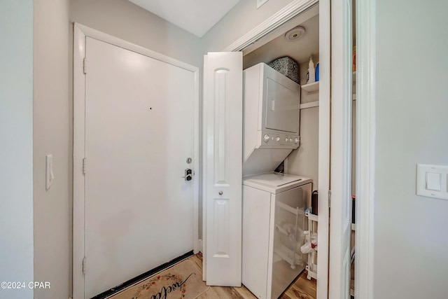 laundry room featuring light hardwood / wood-style floors and stacked washer and clothes dryer