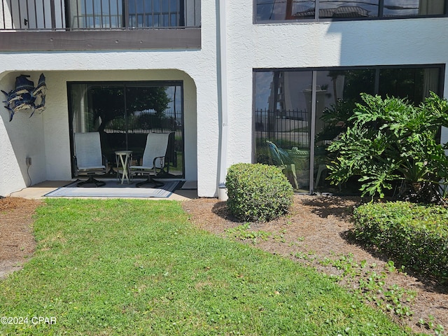 property entrance with a lawn and a patio area