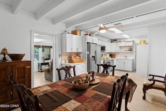 dining room featuring beamed ceiling, sink, and ceiling fan