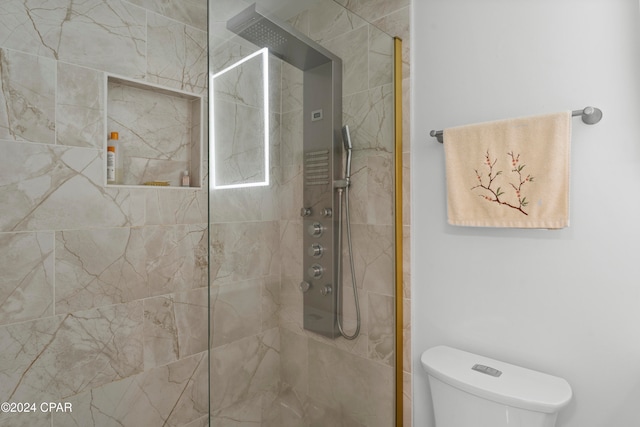 bathroom featuring tiled shower and toilet