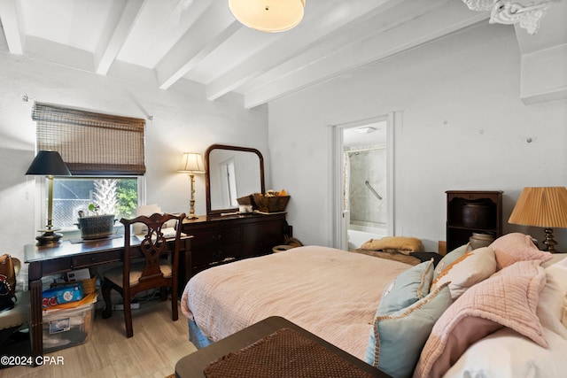 bedroom featuring light hardwood / wood-style floors, beamed ceiling, and connected bathroom