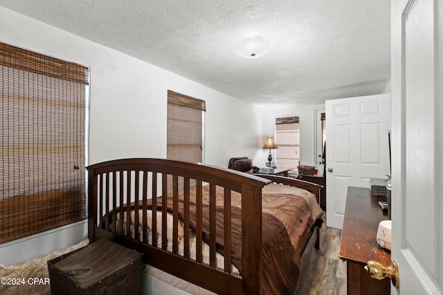 bedroom featuring hardwood / wood-style floors and a textured ceiling