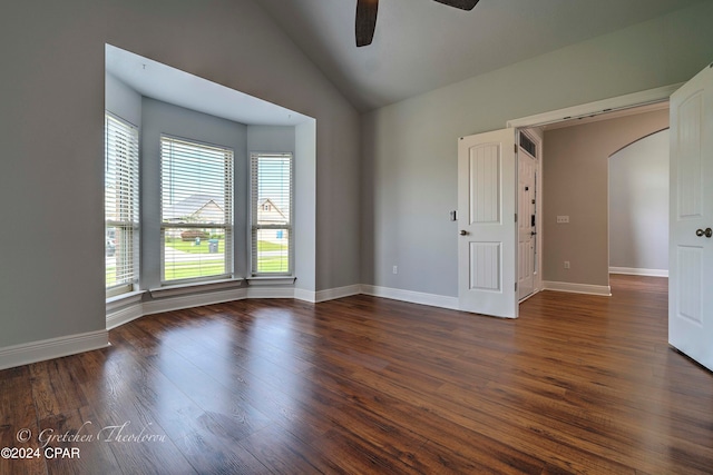 unfurnished room featuring lofted ceiling, ceiling fan, and dark wood-type flooring