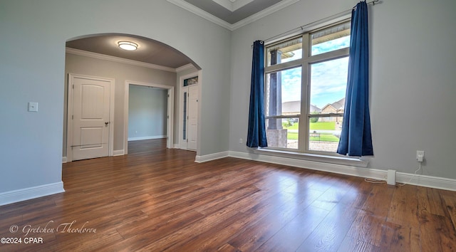 empty room with dark wood-type flooring, a healthy amount of sunlight, and crown molding