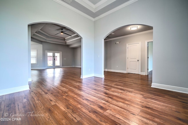 spare room featuring ceiling fan, a raised ceiling, dark wood-type flooring, and crown molding