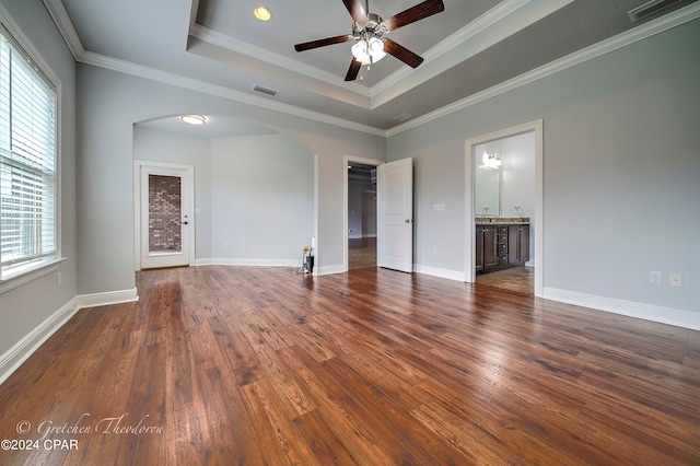 spare room featuring ceiling fan, a raised ceiling, dark wood-type flooring, and crown molding