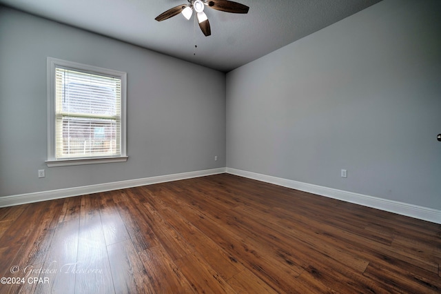 spare room with a textured ceiling, ceiling fan, and dark hardwood / wood-style flooring