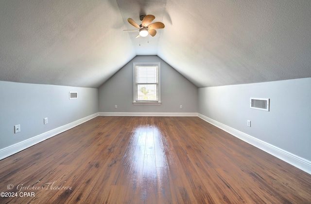 bonus room featuring ceiling fan, a textured ceiling, dark hardwood / wood-style floors, and vaulted ceiling