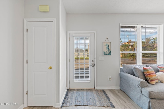 doorway featuring a textured ceiling and light wood-type flooring