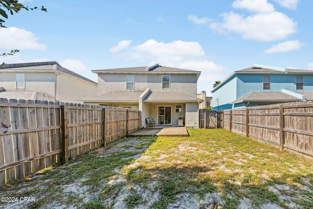 rear view of house with a yard and a patio area