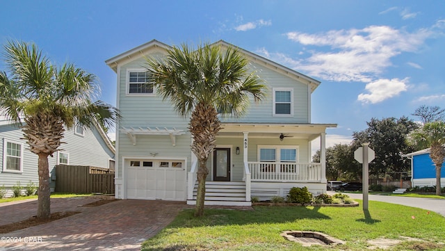 view of front of home featuring a front lawn, covered porch, and a garage