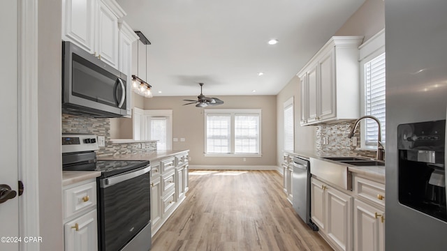 kitchen with a healthy amount of sunlight, white cabinetry, and stainless steel appliances