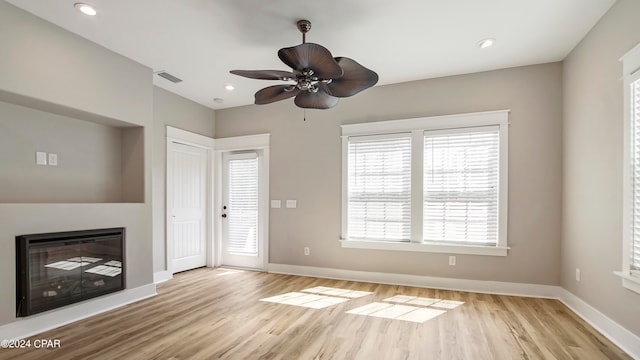 unfurnished living room featuring light hardwood / wood-style flooring and ceiling fan