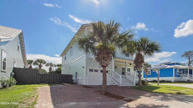 view of front facade with a porch, a garage, and a front lawn