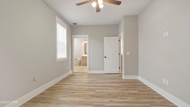 unfurnished bedroom with ensuite bath, light hardwood / wood-style flooring, and ceiling fan